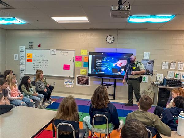 police officer talking to class of students